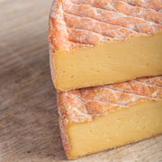 Pieces of cut gubbeen cheese on a wooden board.